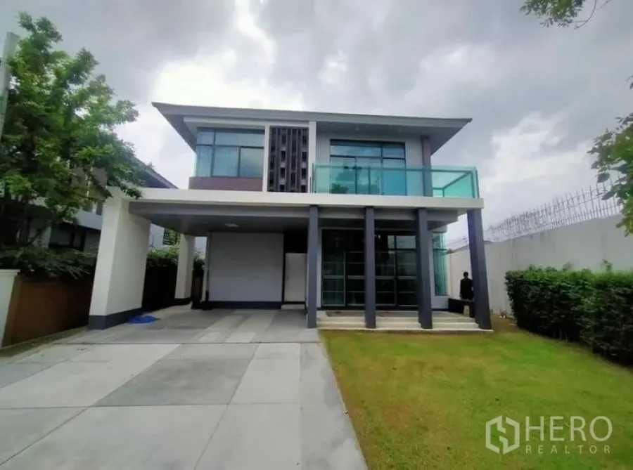Detached House for sale in Prawet, Bangkok - Modern two-storey house exterior with large glass balcony, carport and lawn.