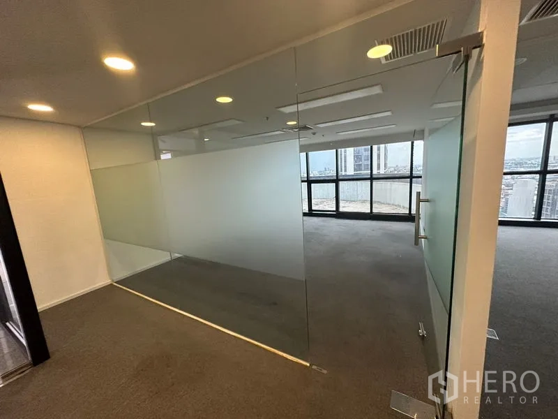 Office Space for rent - Glass-walled meeting room with frosted privacy band and city view.