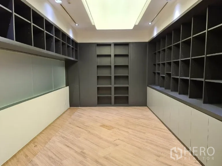 Office Space for rent - Library-style storage room with full-height open shelving on three walls.