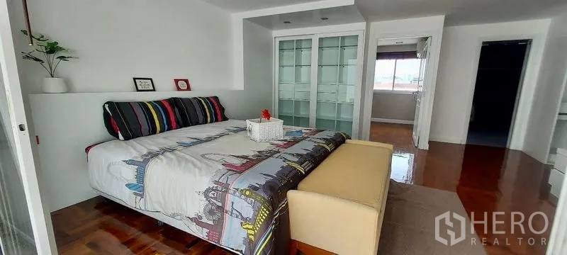 Townhouse for rent in Sathon, Bangkok - Bedroom featuring glass-door wardrobes with direct access to an adjoining room.