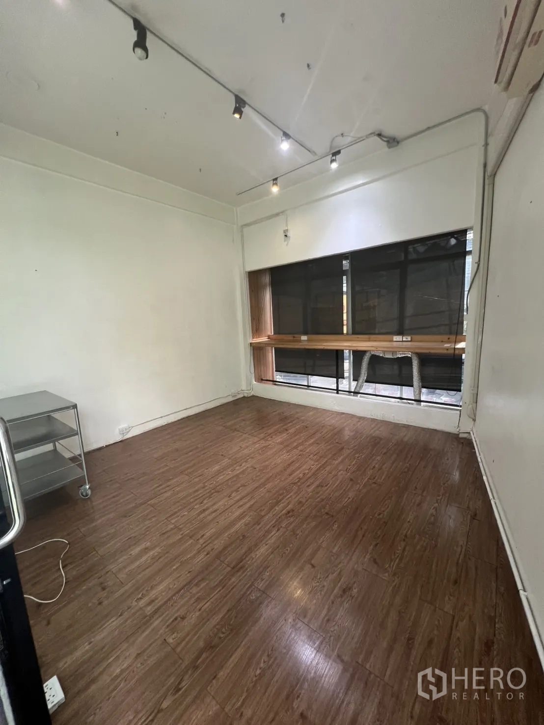 Retail Space for rent in Watthana, Bangkok - Compact room with wood flooring, ceiling spotlights and a front window counter.