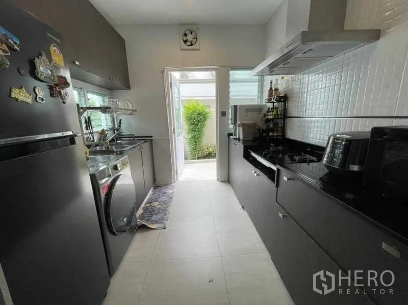Detached House for rent in Bang Khen, Bangkok - Separate Thai kitchen with long counters, gas hob and a door to the backyard.