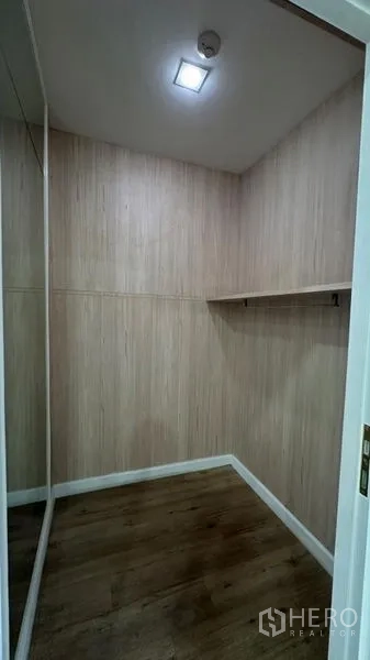 Retail Space for rent - Secondary storage room with wood panel walls, shelf and wood flooring.