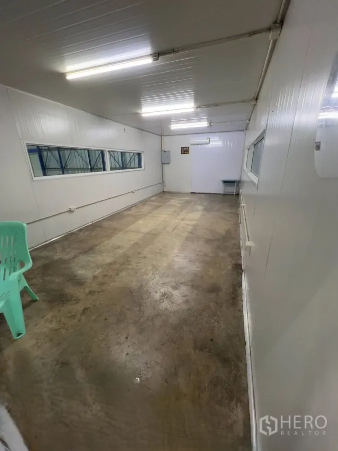 Warehouse for rent in Khlong Luang, Pathum Thani - Enclosed office room inside the warehouse with fluorescent lighting, windows, and a concrete floor.