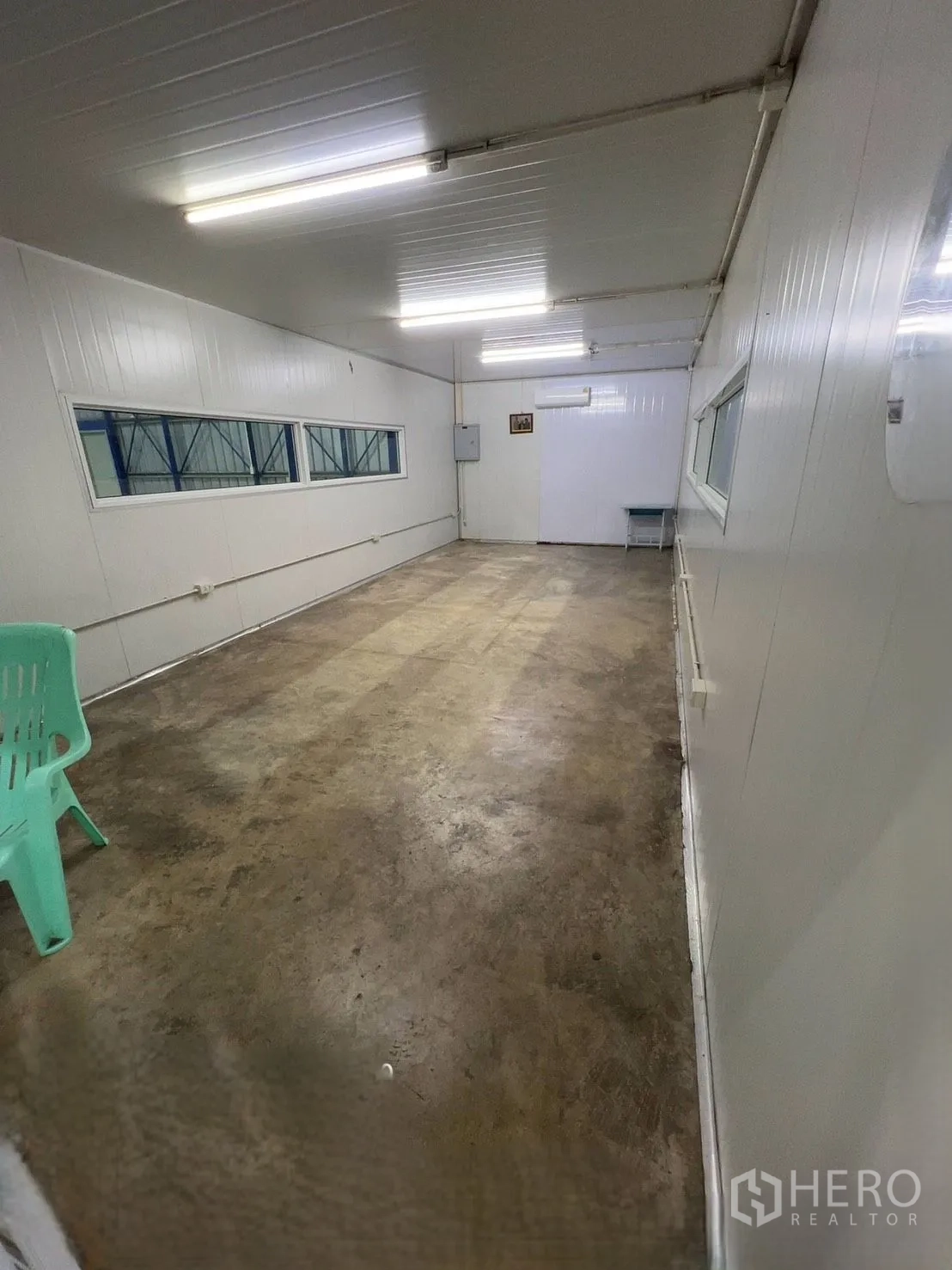 Warehouse for rent in Khlong Luang, Pathum Thani - Enclosed office room inside the warehouse with fluorescent lighting, windows, and a concrete floor.