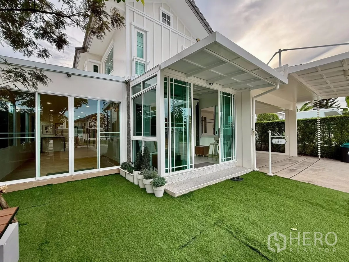 Detached House for rent in Bang Phli, Samut Prakan - Corner garden with artificial lawn and glass sunroom extension beside the house.