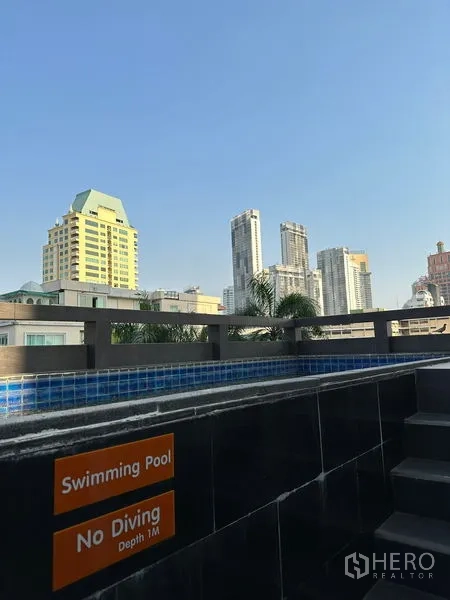 房间 出租在Khlong Toei, Bangkok - 泳池边缘与禁止跳水标识，高楼景观尽收眼底。