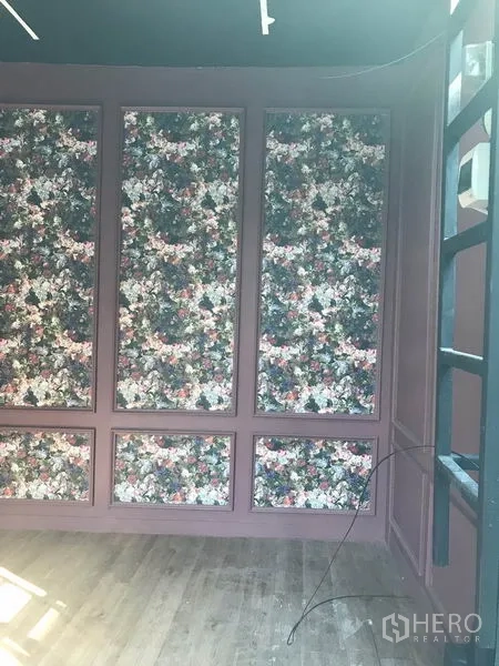 Retail Space for rent in Watthana, Bangkok - Small shop space with decorative floral feature wall, track lighting, and wooden floors.