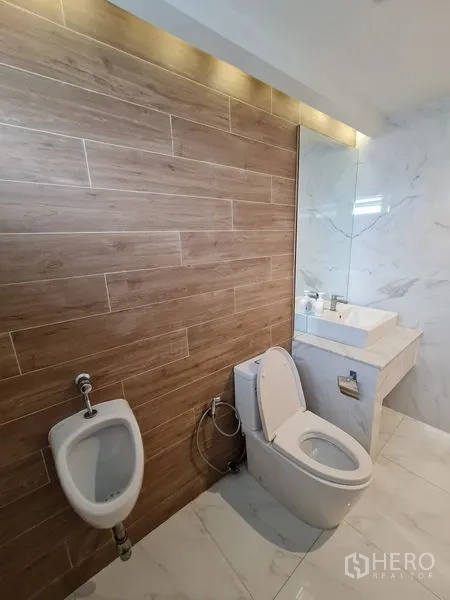 Office Space for rent in Bang Rak, Bangkok - Contemporary restroom with wood-look wall tiles, toilet, urinal, and marble vanity.