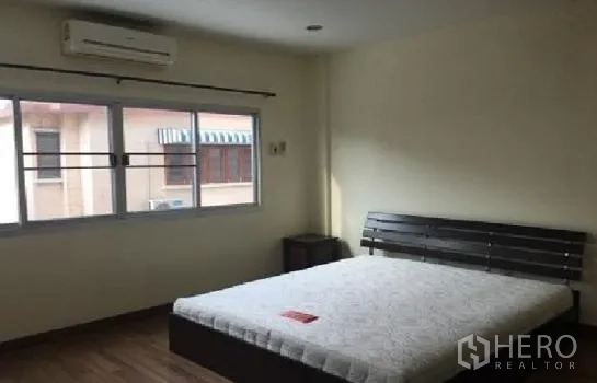 Home Office for rent in Lat Phrao, Bangkok - Air-conditioned bedroom with large window and double bed.