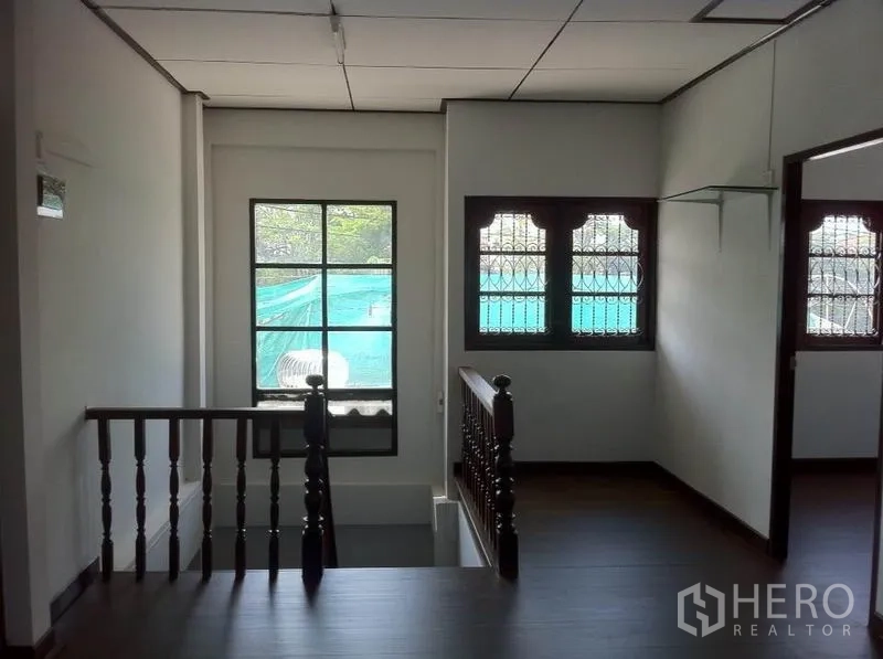 货栈 出租在Lam Luk Ka, Pathum Thani - 楼梯平台，木扶手与带防盗栏的窗户。