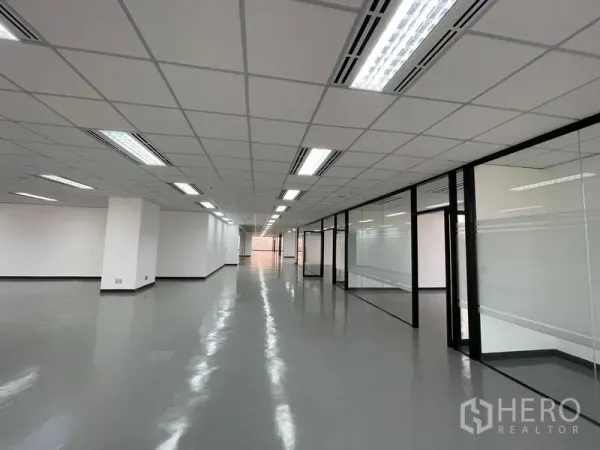 Office Space for rent in Din Daeng, Bangkok - Long office corridor with glass-partitioned meeting rooms and bright ceiling lights.