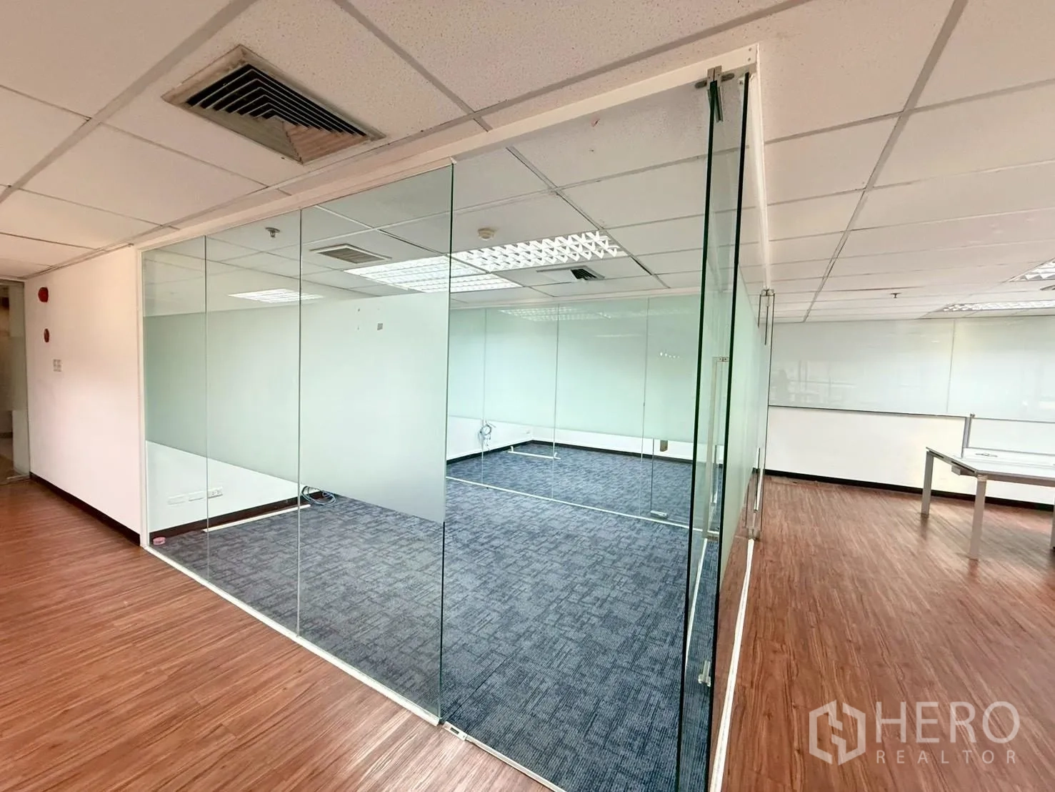 Office Space for rent in Watthana, Bangkok - Corner meeting room enclosed by clear glass with carpet inside and wood floor outside.