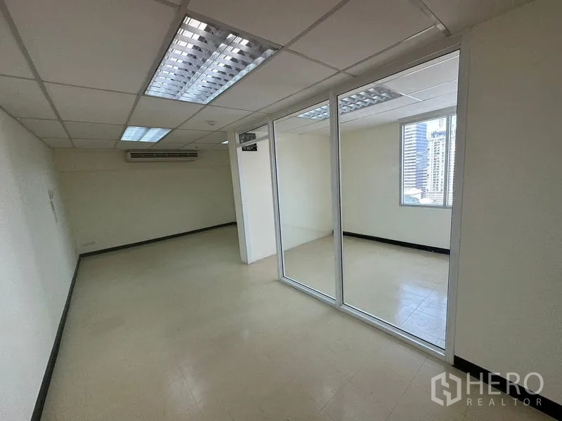 Office Space for rent in Watthana, Bangkok - Open-plan office with glass-partitioned room, drop ceiling and city-view window in Watthana, Bangkok.