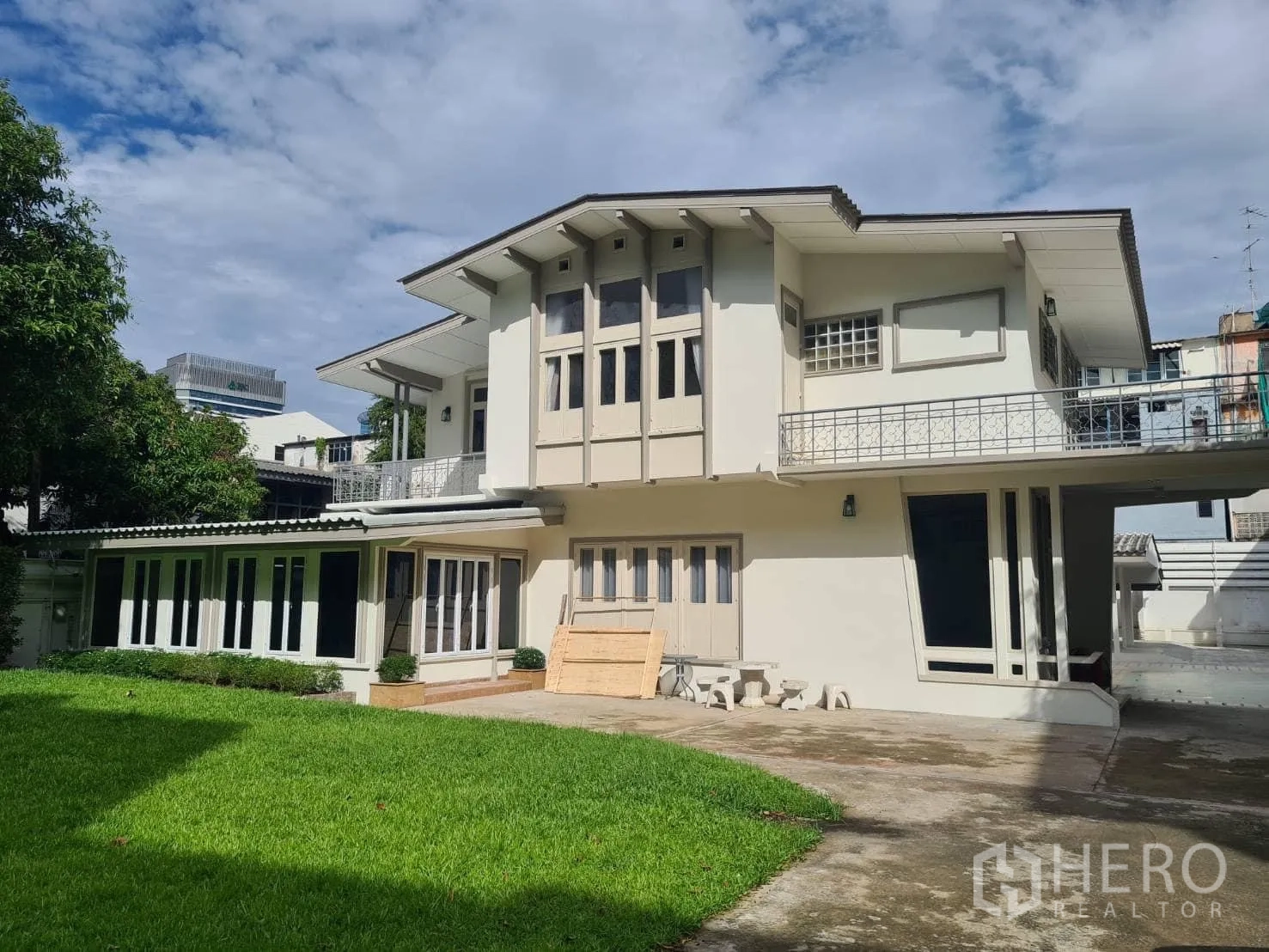 Detached House for rent in Khlong Toei, Bangkok - Two-storey detached house with wide lawn and balconies in Khlong Toei near Ekkamai BTS under a blue sky.