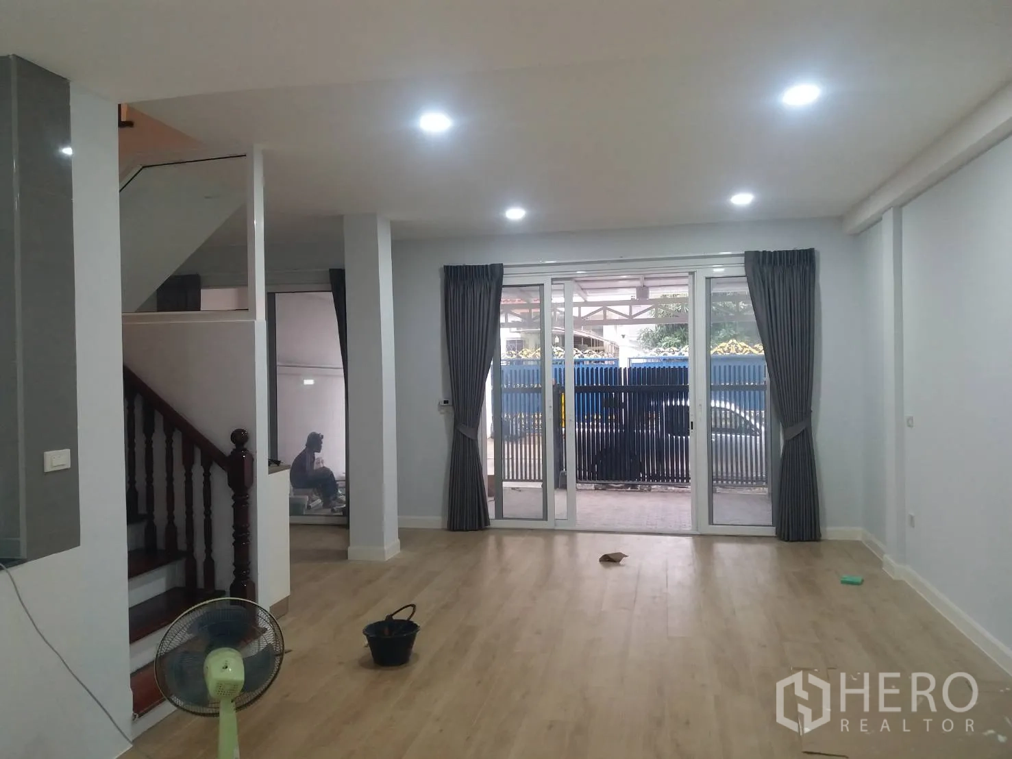 Townhouse for rent in Khlong Toei, Bangkok - Bright open-plan living room with wood floors, recessed lights and sliding glass doors.