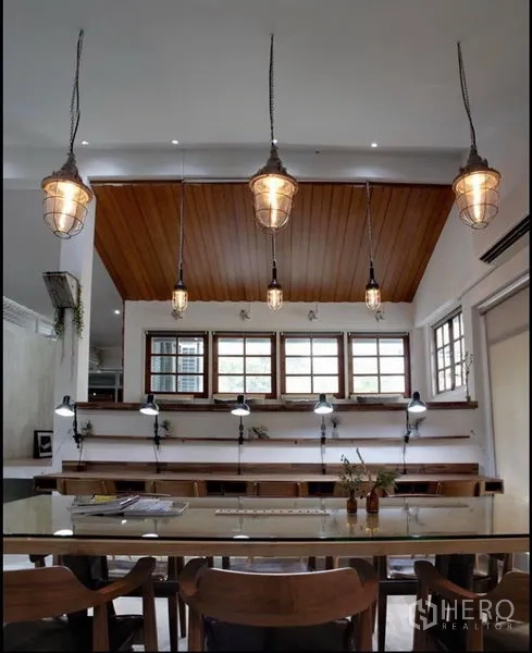 Home Office for rent in Khlong Toei, Bangkok - Meeting zone with a timber ceiling, caged pendant lights, long counter desks and windows bringing natural light.