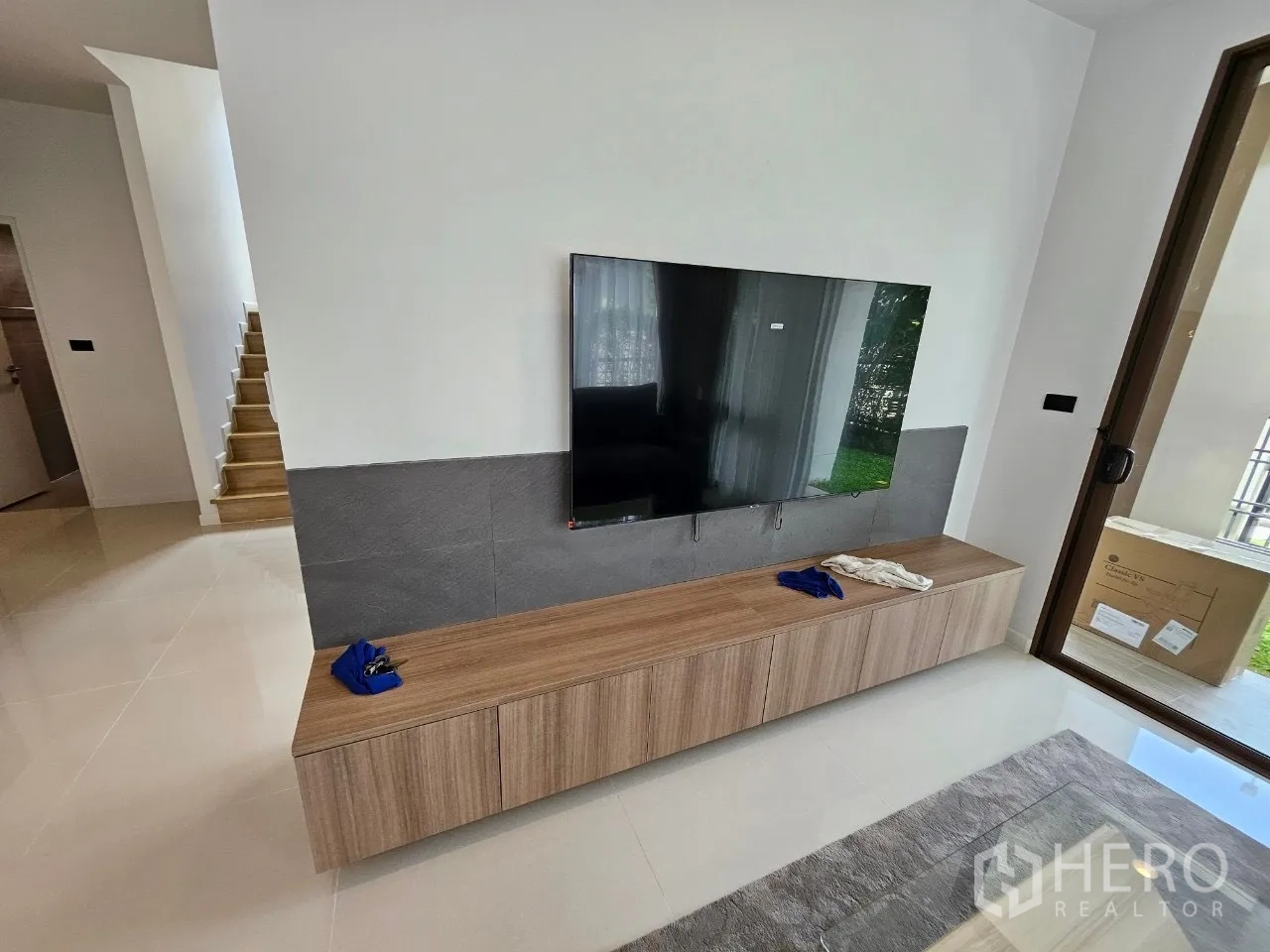 Detached House for rent in Bang Kapi, Bangkok - TV wall with mounted flat-screen and long wooden media cabinet.