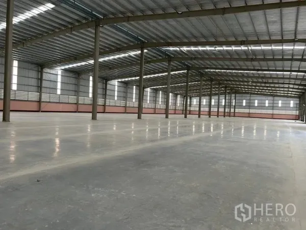 Warehouse for rent in Nikhom Phatthana, Rayong - Clean warehouse floor area with ventilated side walls and ample natural light across the space.