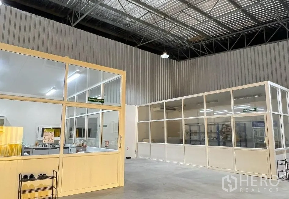 工厂 for rent or sale in Sai Noi, Nonthaburi - 工厂内部配高金属屋顶、玻璃隔断的洁净室与办公室、明亮照明和混凝土地面。