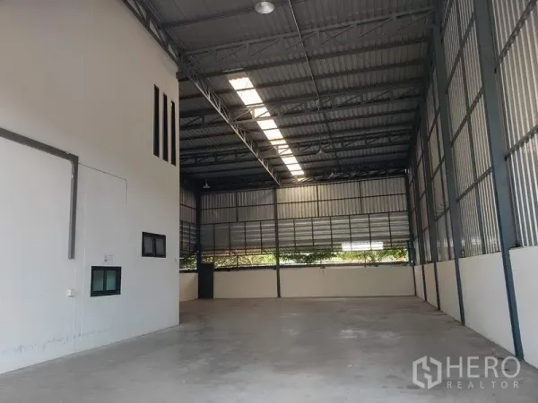 Factory for rent or sale in Lam Luk Ka, Pathum Thani - Spacious production hall with concrete floor and louvered panels for airflow.