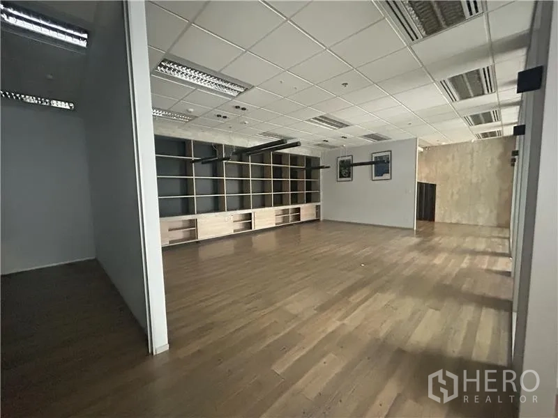 Office Space for rent - Spacious open-plan office with full-wall shelving and wood floors