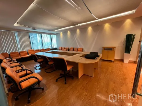 Office Space for rent in Khlong Toei, Bangkok - Large boardroom featuring a U-shaped conference table, orange chairs and window blinds.