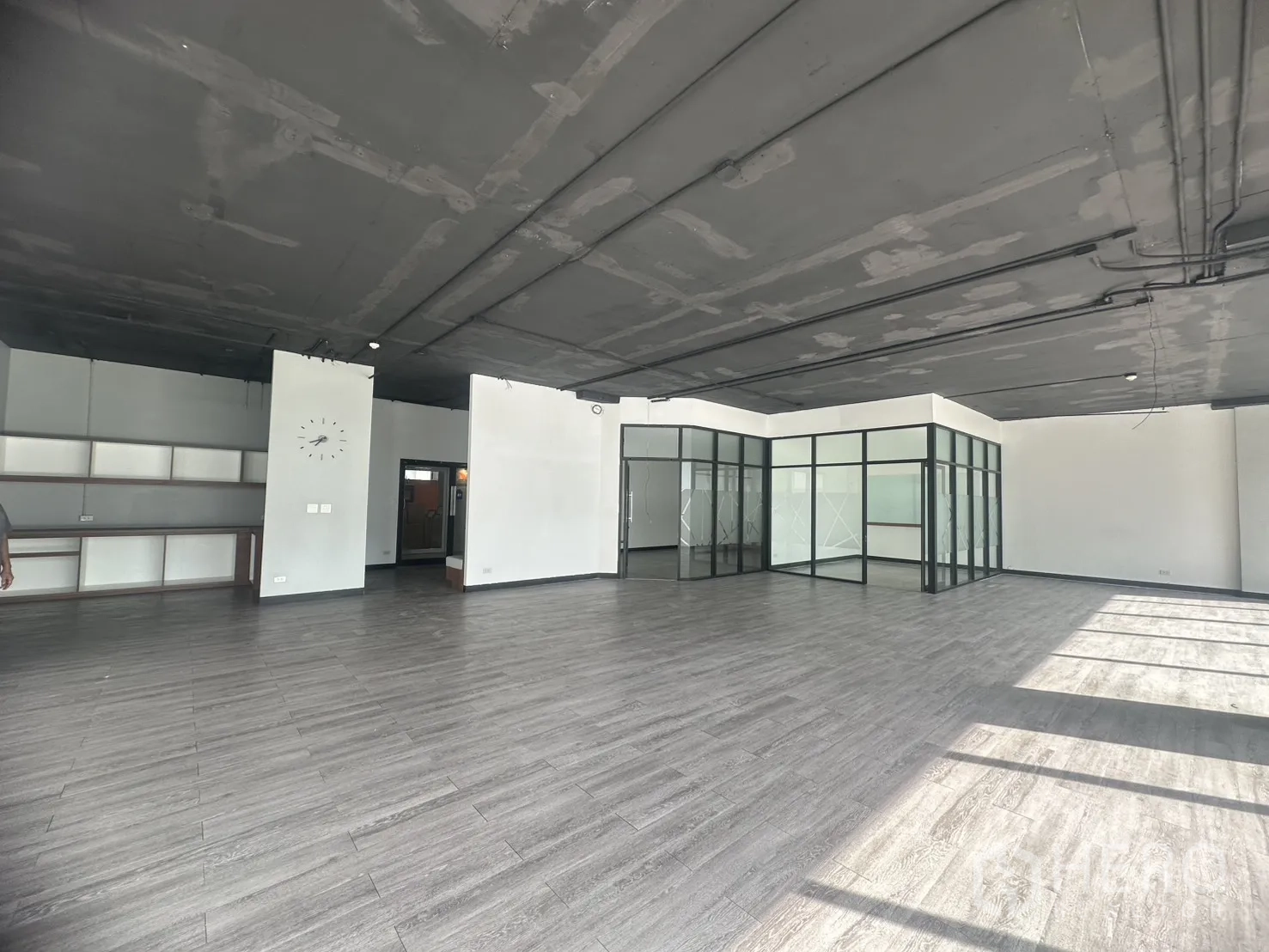 Office Space for rent in Khlong Toei, Bangkok - Spacious workspace with exposed ceiling, glass‑partitioned rooms, and built‑in shelves.