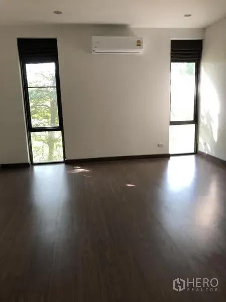 บ้าน ให้เช่าในPrawet, Bangkok - ห้องนอนพื้นไม้ มีหน้าต่างสูงสองบาน และเครื่องปรับอากาศติดผนัง
