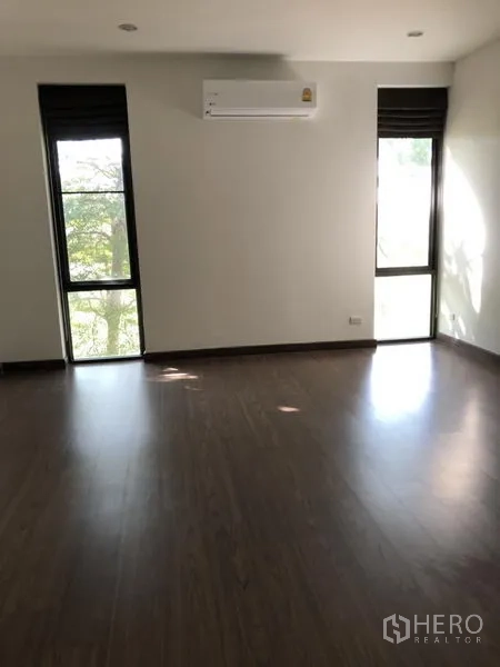 บ้าน ให้เช่าในPrawet, Bangkok - ห้องนอนพื้นไม้ มีหน้าต่างสูงสองบาน และเครื่องปรับอากาศติดผนัง