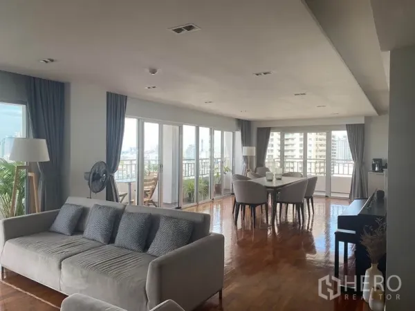 Condominium for rent in Sathon, Bangkok - Bright living-dining space wrapped by windows and sliding doors leading to the balcony.