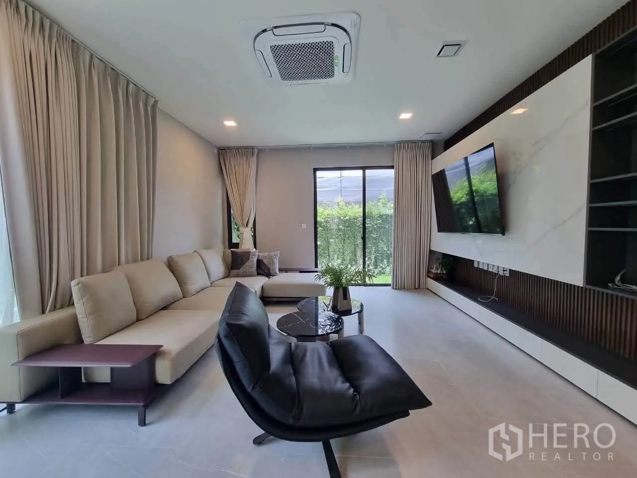 บ้านเดี่ยว for rent in Bang Phli, Samut Prakan - ห้องนั่งเล่นโมเดิร์น โซฟาตัวแอล ผนังทีวี และประตูกระจกสู่สวน