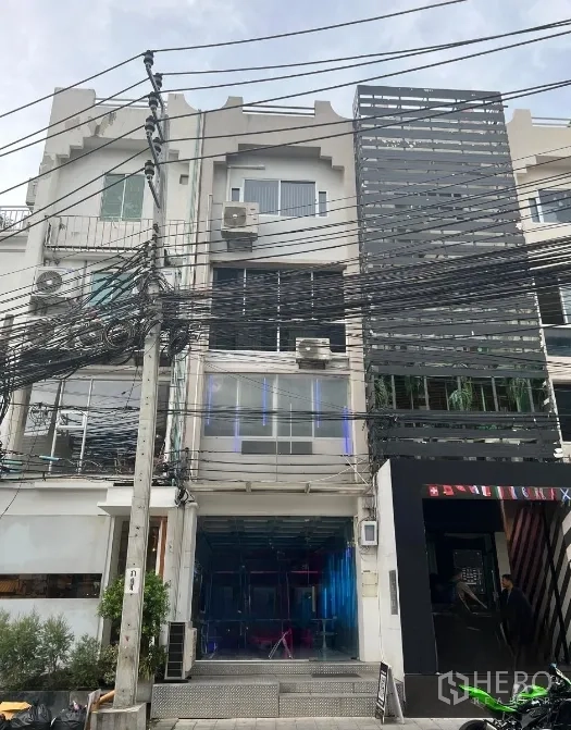 Shophouse for rent or sale in Watthana, Bangkok - Full front elevation of four-storey shophouse with large windows and signage frames in the Sukhumvit area.