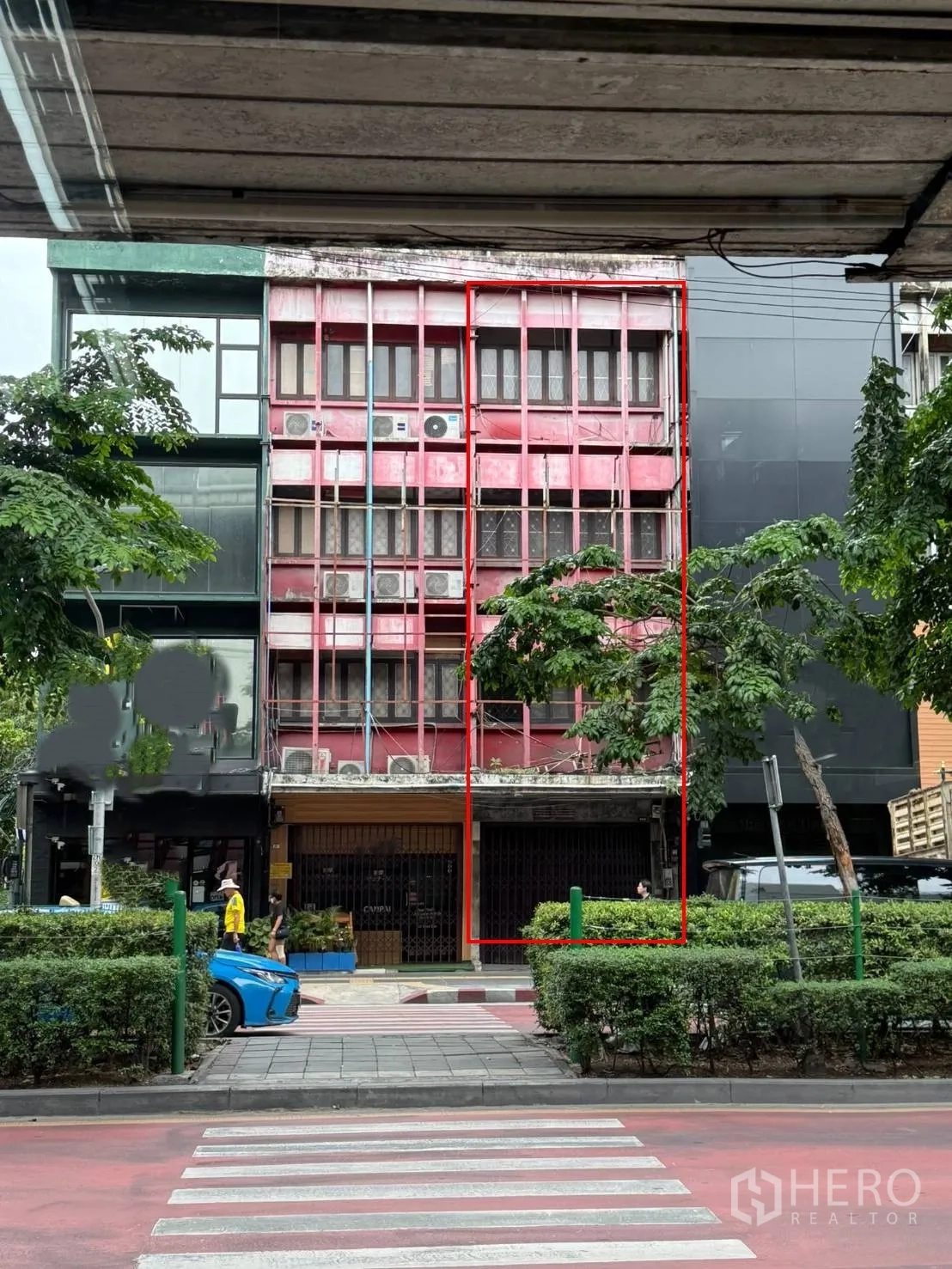 Shophouse for rent in Khlong Toei, Bangkok - Full building exterior marked within a red outline across from a crosswalk.