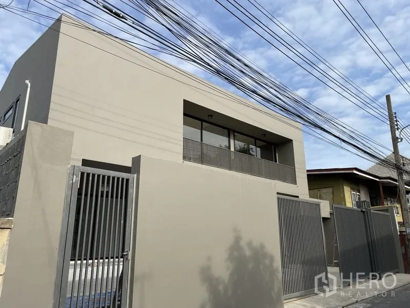 Home Office for rent in Khlong Toei, Bangkok - Corner exterior view of minimalist two-storey building with secure fencing