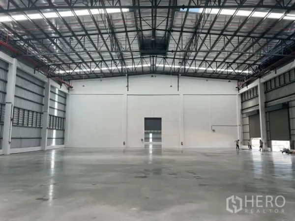 Factory for rent in Bang Pakong, Chachoengsao - Spacious warehouse interior with polished concrete floor and high clear-span steel roof with skylights.