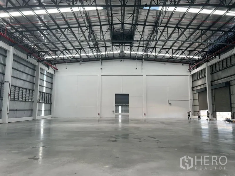 Factory for rent in Bang Pakong, Chachoengsao - Spacious warehouse interior with polished concrete floor and high clear-span steel roof with skylights.