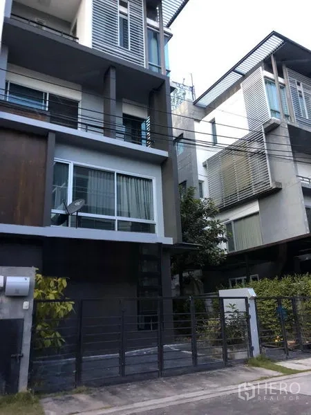 Home Office for sale in Wang Thonglang, Bangkok - Street view of gated modern home office with large windows in Bangkok