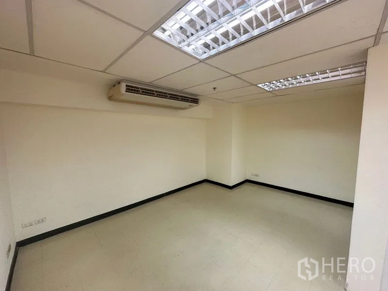 Office Space for rent in Watthana, Bangkok - Compact office room with wall-mounted air conditioner and fluorescent ceiling lights.