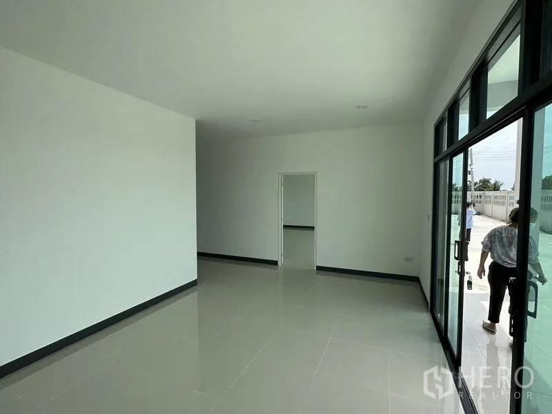 Factory for rent or sale in Sai Noi, Nonthaburi - Ground‑floor office area with sliding glass entrance, bright tiles and connection to yard.
