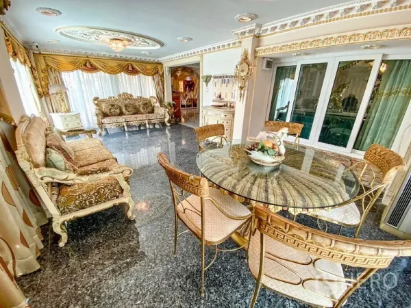 Detached House for rent or sale in Bang Khen, Bangkok - Elegant living and dining area with ornate gold-trimmed furniture, granite floors, and large windows.