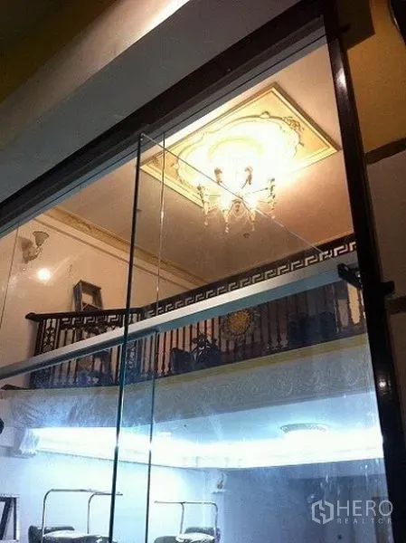 Home Office for rent or sale in Sathon, Bangkok - Double-height lobby viewed through glass, featuring a chandelier and mezzanine railing in classic design.