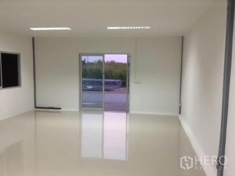 货栈 出租在Bang Kapi, Bangkok - 仓库内明亮的办公室，白色墙面、亮面地坪、推拉玻璃门与顶灯。