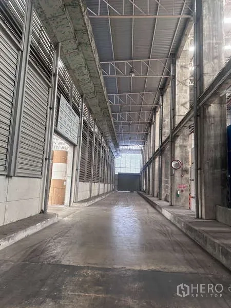 工厂 出租 - 有顶装卸月台与服务走道，高屋顶与混凝土坡道。