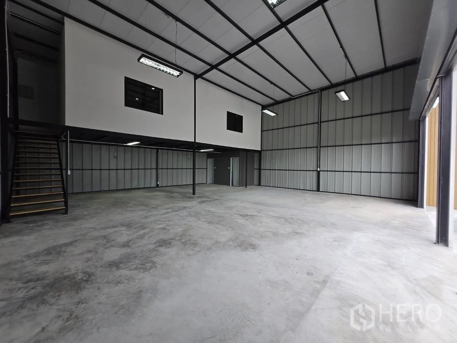 Warehouse for rent - High-ceiling warehouse interior with steel structure, mezzanine and polished concrete floor.