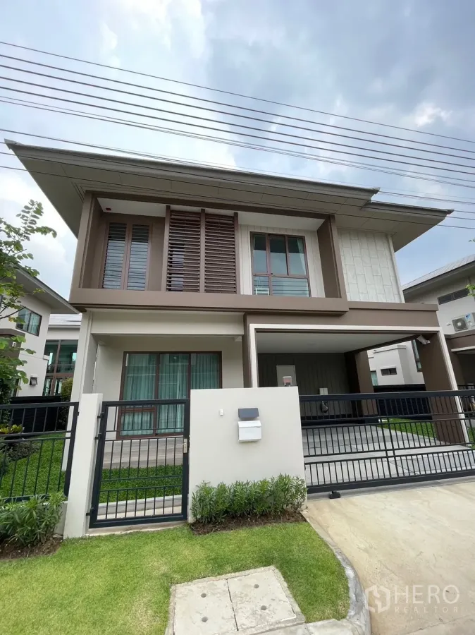 Detached House for rent in Bang Kapi, Bangkok - Modern two-story detached house facade with gated driveway, lawn, and carport in Bang Kapi.