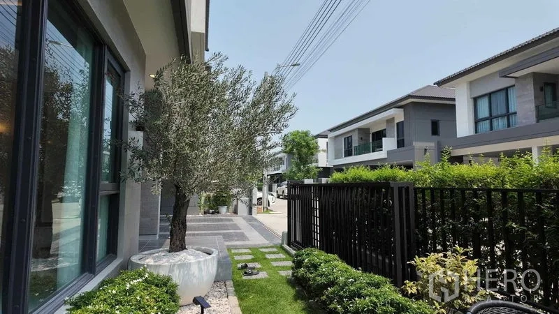 独立式住宅 出租或出售在Bang Na, Bangkok - 前花园与小区街景，可见现代住宅排布。