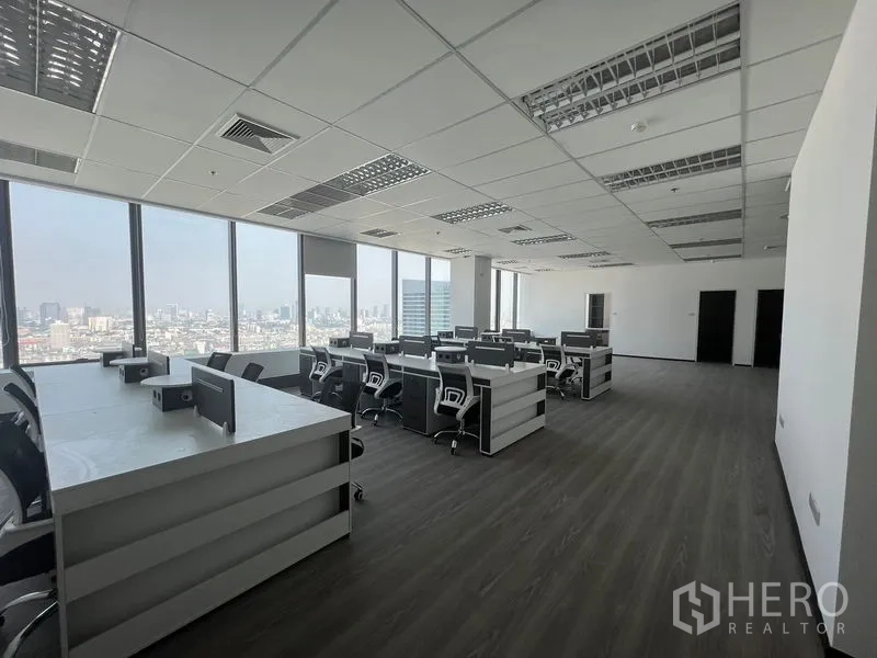 办公空间 出租在Huai Khwang, Bangkok - 开放式办公区，成排工位与滚轮椅，大窗城市景观。