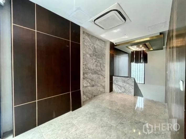 Detached House for rent or sale in Khlong Toei, Bangkok - Upper-floor landing with marble accents, built-in lighting and ceiling cassette air-conditioning.
