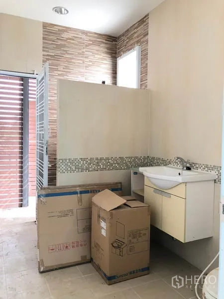 Detached House for sale in Bang Khen, Bangkok - Tiled utility or laundry area with window, exterior door and wall-mounted sink with storage cabinet.